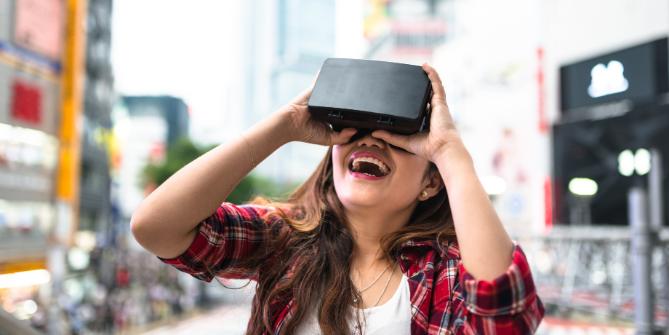Young woman laughing, wearing virtual reality headset