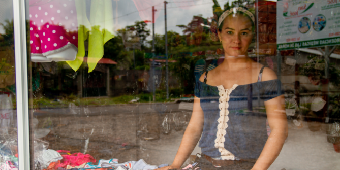 The young woman Ana Maria Guarjila behind the shop window of her clothing shop